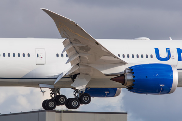 A 787 lands at Paine Field with ram air turbine deployed. The frame is cropped to just the midesction showing the engines and wings.