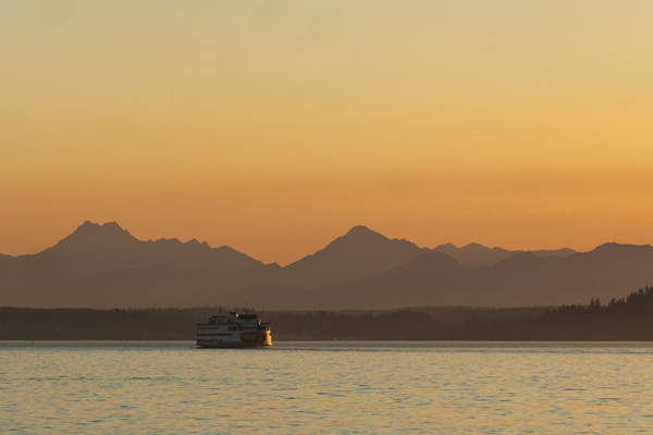 Ferry at sunset on puget sound with the Olympic mountains silhouetted in the background